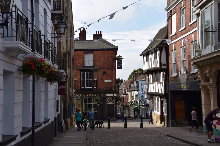 Her i Bailgate parkerer jeg Harley'en og tar det første fotoet i Lincoln - plassen Castle Hill rett frem og gaten Steep Hill litt til høyre i bildet. Foto: © ReisDit.no